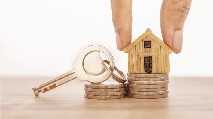 A small wooden house and keys, representing a new chapter at home